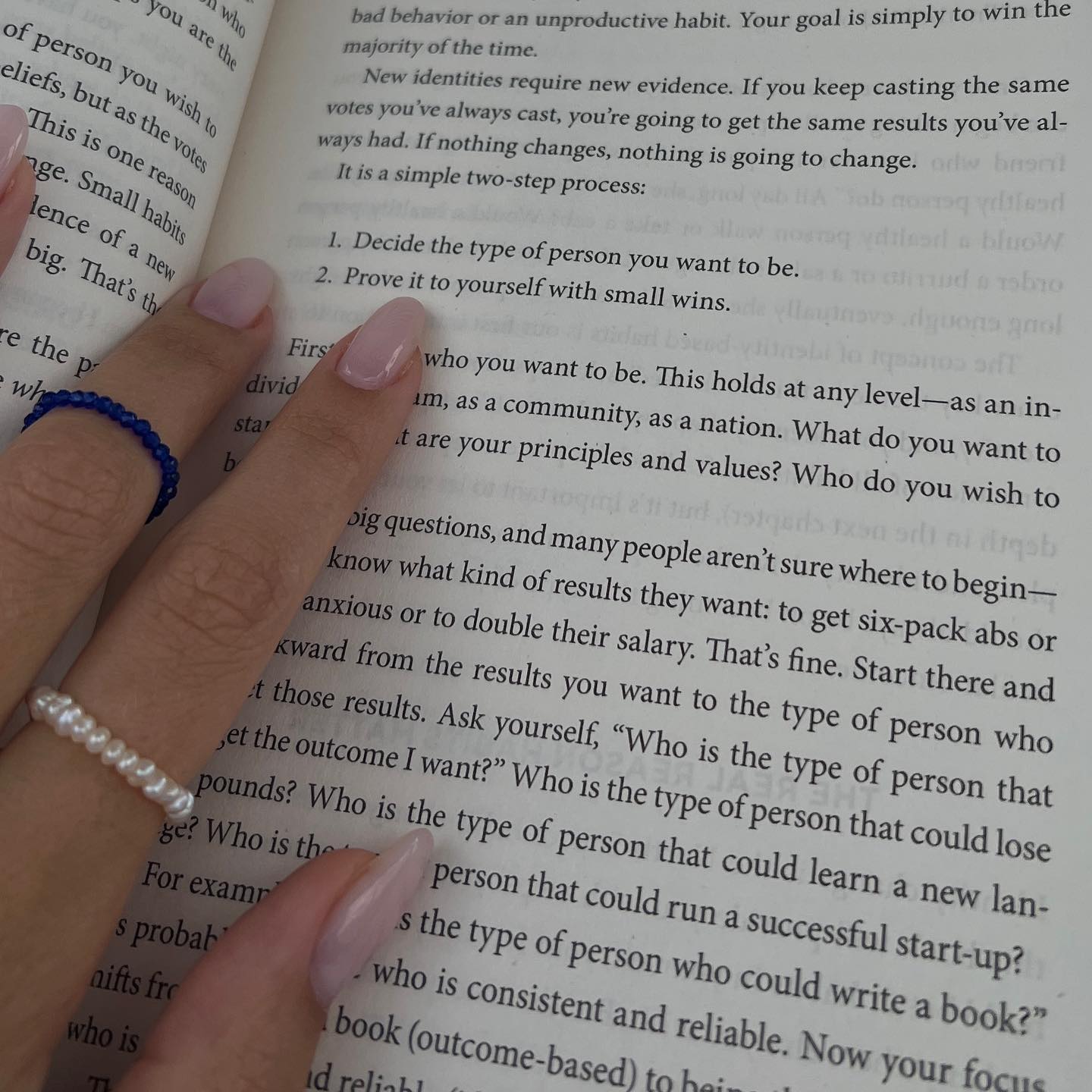 Pearl ring on a hand holding a book