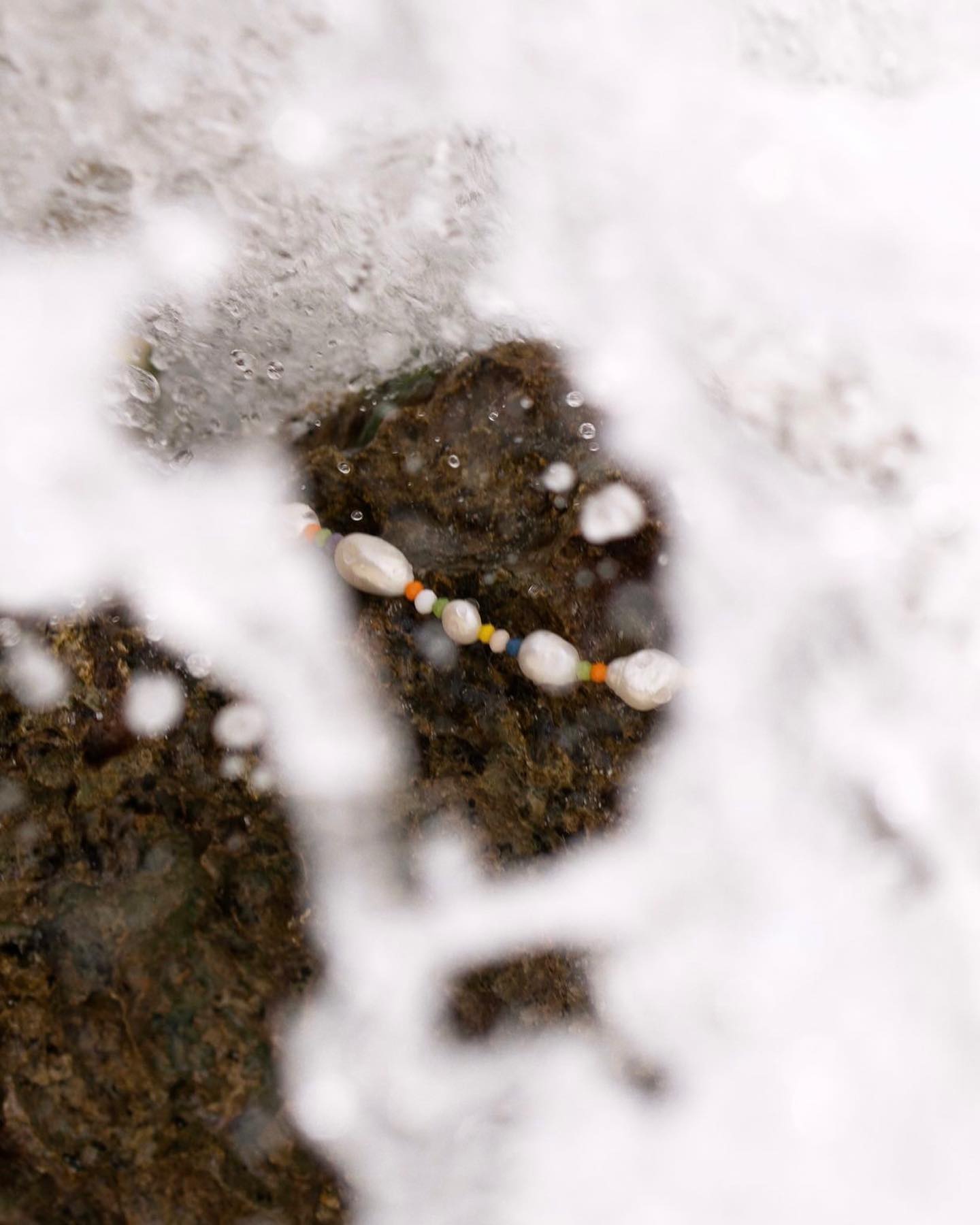 Pearl bracelet on a wet rock